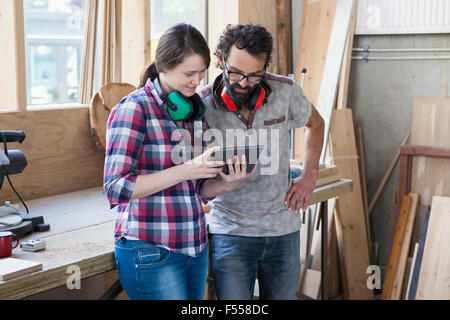 Mid adult carpenters using digital tablet in workshop Stock Photo