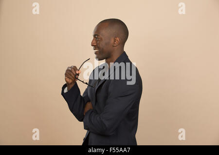 Thoughtful man smiling while looking away against colored background Stock Photo