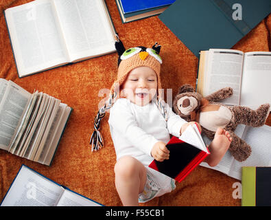 One year old baby reading books with teddy bear Stock Photo