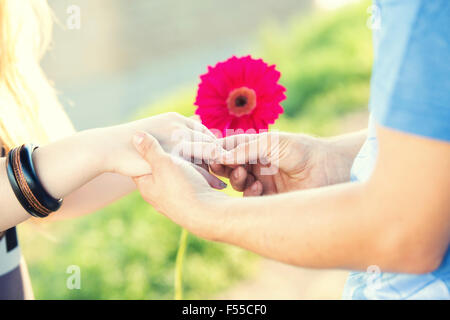 engagement ring on a flower in the hands of the bride Stock Photo