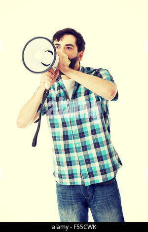 Young man shouting through megaphone. Stock Photo