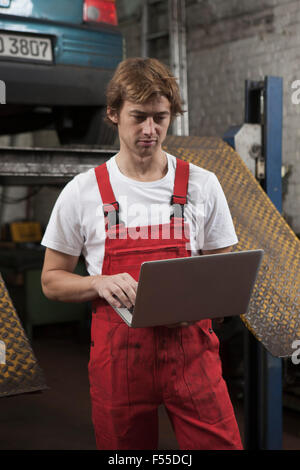 Mechanic using laptop at garage Stock Photo