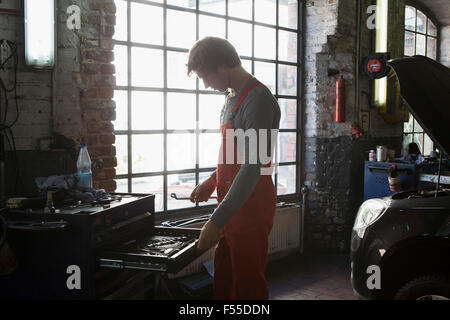 Side view of mechanic removing work tools from drawer at garage Stock Photo