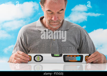 Senior man using measure level at home. Stock Photo