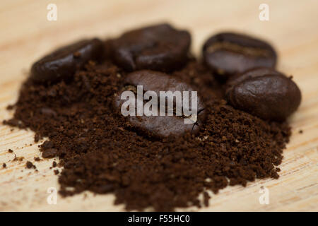 Whole organic coffee beans in a mound of ground organic coffee. Stock Photo