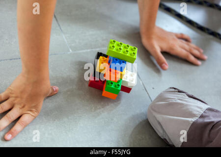 Lego bricks, Plastic cubes in the hands of a child's game that develops creativity and imagination Stock Photo