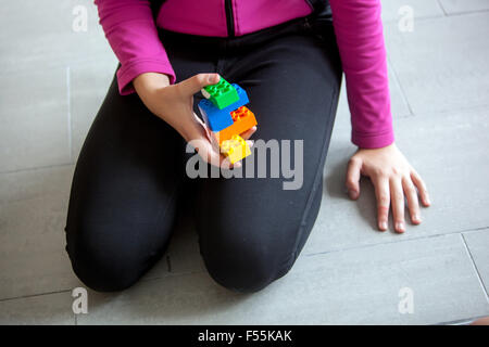 Lego bricks, Plastic cubes in the hands of a child's game that develops creativity and imagination Stock Photo