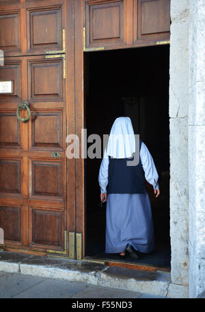 nun entering the old Cathedral of Eivissa, Ibiza Spain Stock Photo