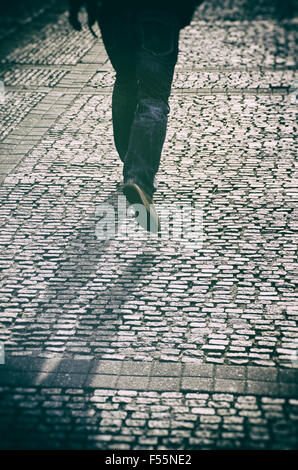 Mysterious man running on a cobbled street Stock Photo