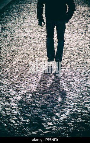 Mysterious man running on a cobbled street Stock Photo