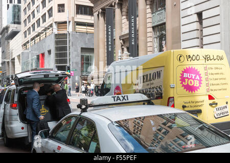 australian taxi in george street Sydney parked behind another with guests exiting the vehicle,Sydney Stock Photo