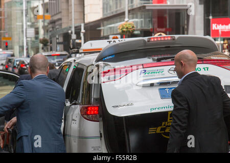 australian taxi in george street Sydney with businessmen recovering their luggage from the boot,Sydney,australia Stock Photo
