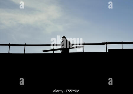 Construction worker silhouette on a construction with blue sky on background Stock Photo