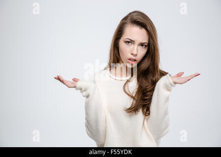 Portrait of a young casual woman shrugging shoulders isolated on a white background Stock Photo