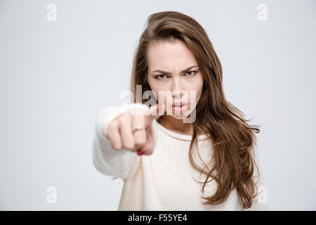 Portrait of a young angry woman pointing finger at camera isolated on a white background Stock Photo