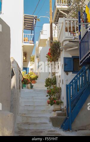 Street in Mykonos, Greece. Typical combination of blue and white color. Flowers on the stairs and balconies. Stock Photo