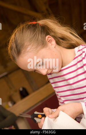 10 year old girl learning how to unpick stitching during a mother & daughter sewing day, Selborne, near Alton, Hampshire, UK. Stock Photo