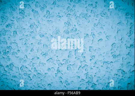Snowed window blue abstract, texture of rain and snow, melting drops and frozen flakes on window glass, blue background Stock Photo