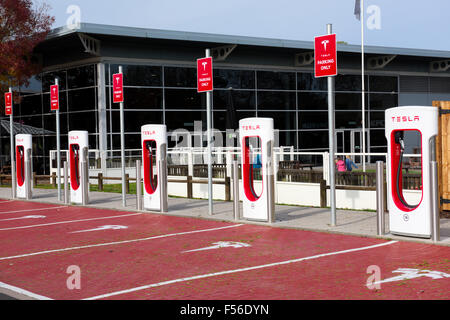 Row of Tesla Supercharger electric car charging stations at M42 motorway services Welcome Break Hopwood Park Stock Photo