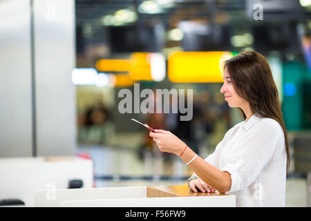 Beautiful woman with passports and boarding passes at the front desk at airport Stock Photo