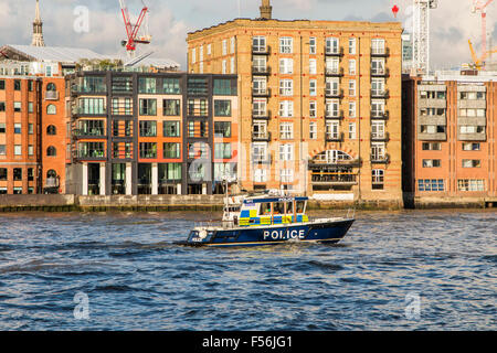 Marine Police Force or Thames River Police boat on the River Thames passing the Samuel Pepys pub in the riverbank, London, UK on a sunny day Stock Photo