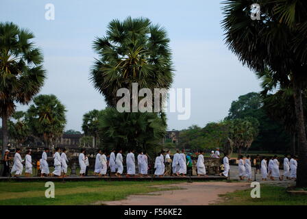 Line of female Buddhist monks walk past Angkor Wat complex. Angkor Wat was first a Hindu, then subsequently, a Buddhist complex. Stock Photo