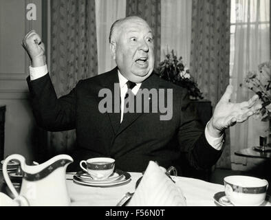 The director Alfred Hitchcock wielding a butter knife at breakfast, Claridge's Hotel, London, UK Stock Photo