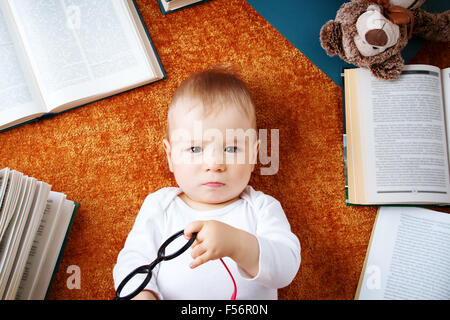One year old baby with spectackles and a teddy bear Stock Photo