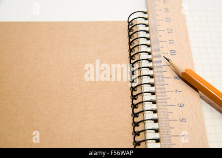 Opened notebook with a blank sheet, pencil and wooden ruler on over white Stock Photo