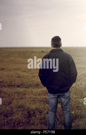 Handsome middle aged man walking through a rural coastal area Stock Photo