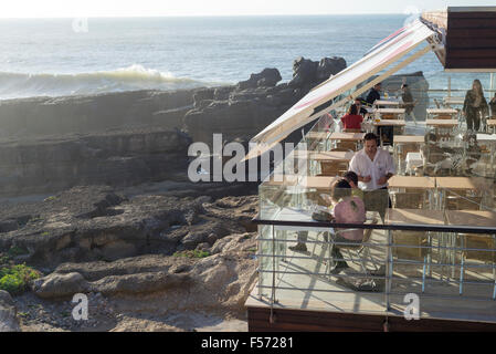 People inside RESTAURANT overlooking ocean, Ericeira, Portugal Stock Photo