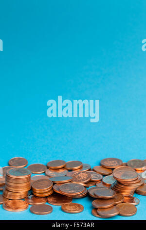 Euro cent coins in one cent and two cents denominations on blue background. Stock Photo