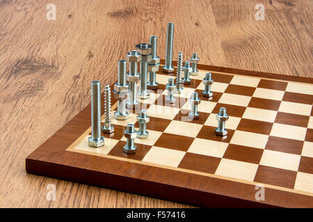 Chess set made from nuts and bolts with the pieces moved across the board as if playing. Stock Photo