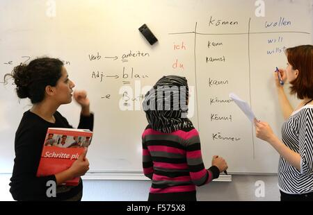 Leipzig, Germany. 27th Oct, 2015. In an integration course for women, participants from Syria and Iran stand at the board with Iranian teacher Shamim Shahi Irani (L) at the Language Coach Institut in Leipzig, Germany, 27 October 2015. The number of course participants had to be increased from 15 to 20 on account of the strong demand for German courses at the language institute. Special courses for women give participants childcare options during class. Photo: Waltraud Grubitzsch/ZB/dpa/Alamy Live News Stock Photo