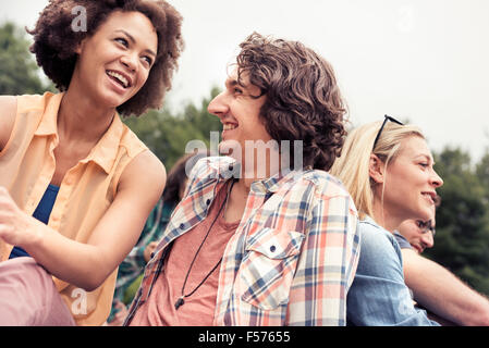 A young couple, a man and woman among others outdoors in the countryside. Stock Photo