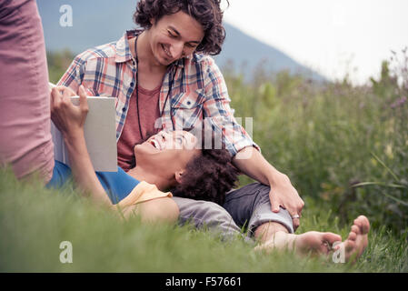 A couple, a woman with an open book looking up at a man smiling at him. Stock Photo
