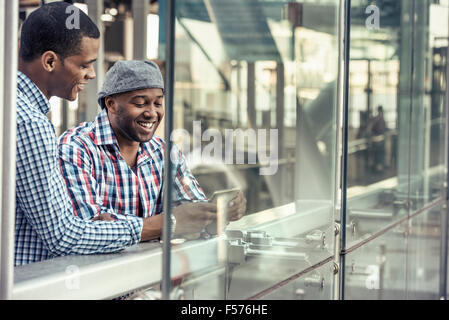 Two men side by side looking at a digital tablet Stock Photo
