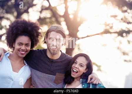 Three people, a man and two women side by side smiling Stock Photo