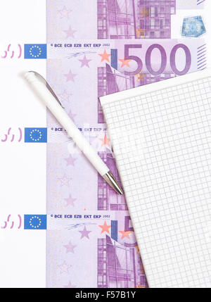 Various euro notes next to notepad Stock Photo