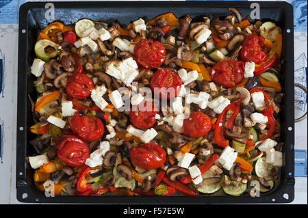 Roasted vegetables with feta cheese on a baking tray Stock Photo