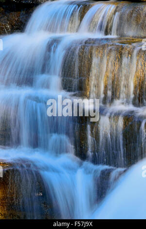 A vertical landscape image of rushing water cascading  over steps in the Athabasca falls Stock Photo