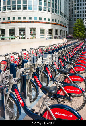 Santander red Boris Bikes for hire in a docking station Canary Wharf London England UK GB EU Europe Stock Photo