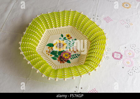 Empty plastic cake dish with painted flowers on a old handmade table cloth from the North of Sweden Stock Photo