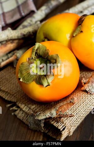 fresh natural kaki fruits on wooden table Stock Photo