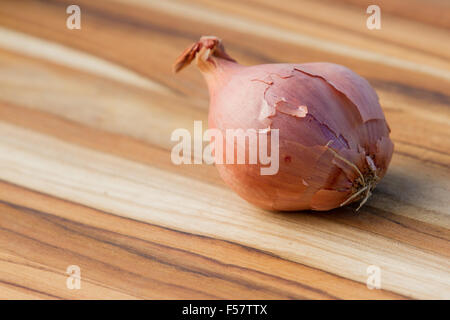 close up of an organic shallot on a wooden table Stock Photo