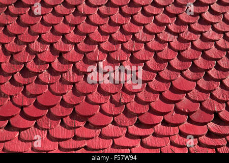Swiss Alpine house close up of miniature red wooden tiles on walls. Stock Photo