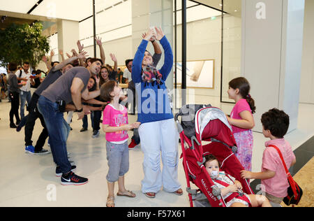 (151029) -- DUBAI, Oct. 29, 2015 (Xinhua) -- Customers take a group selfie in an Apple Store during its opening day at a shopping mall in Dubai, United Arab Emirates, Oct. 29, 2015. Apple has opened its first retail stores in the Middle East with two shops in the United Arab Emirates. The two new stores for the Cupertino, California-based technology giant are in Dubai's Mall of the Emirates and Abu Dhabi's Yas Mall. (Xinhua/Li Zhen) Stock Photo