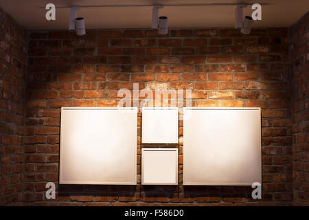 blank white boards in frames on brick wall, abstract interior background with place for text Stock Photo