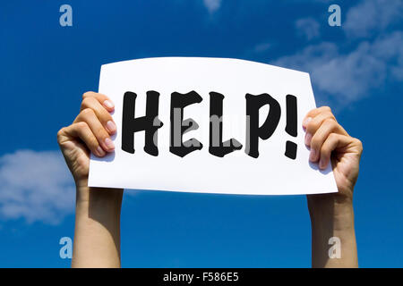 Help sign in hands on blue sky background Stock Photo