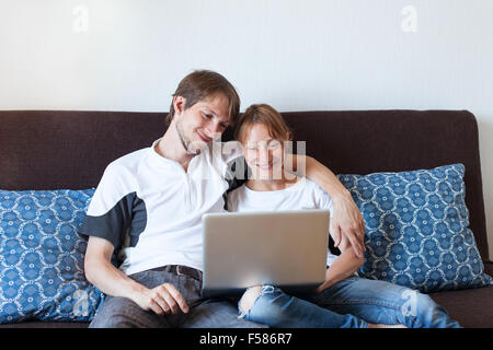 happy smiling couple with laptop at home, shopping online Stock Photo